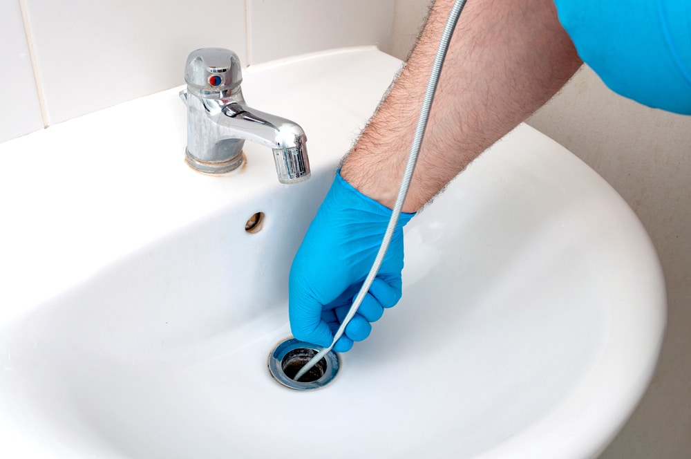 Illustration of a clogged drain with standing water and debris. Learn the seven indications you need drain cleaning to prevent potential health hazards and major damage to your home.